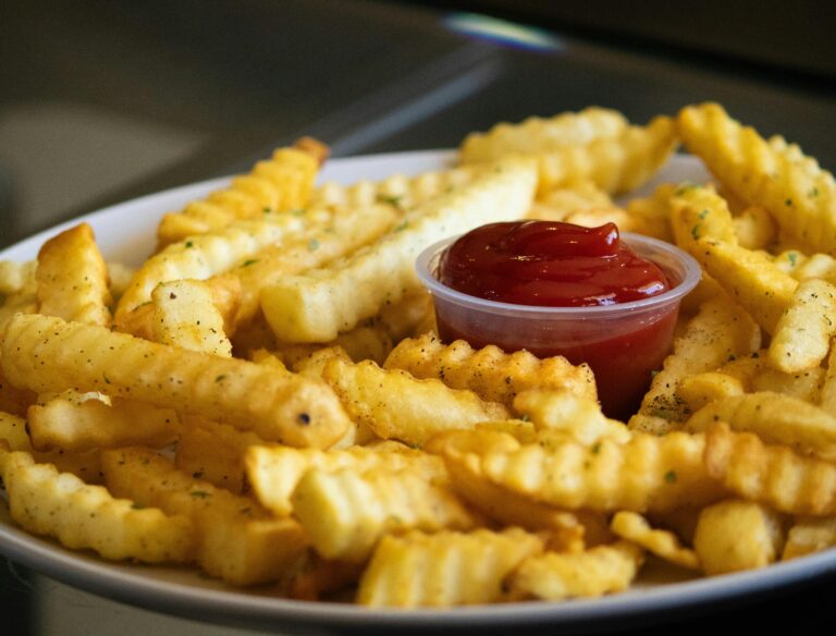 Golden crispy air fryer french fries in a white bowl with sea salt seasoning