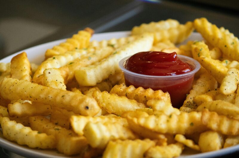 Golden crispy air fryer french fries in a white bowl with sea salt seasoning